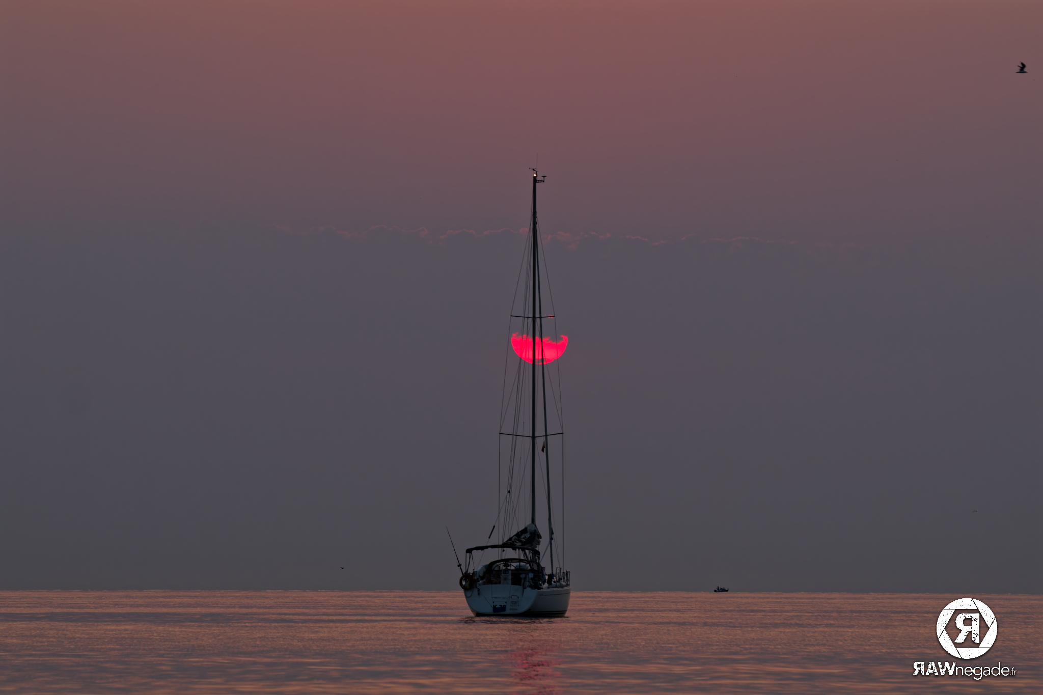 Un voilier au lever de soleil
